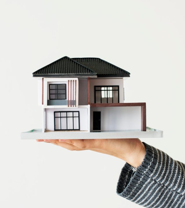 Hand presenting model house for home loan campaign
